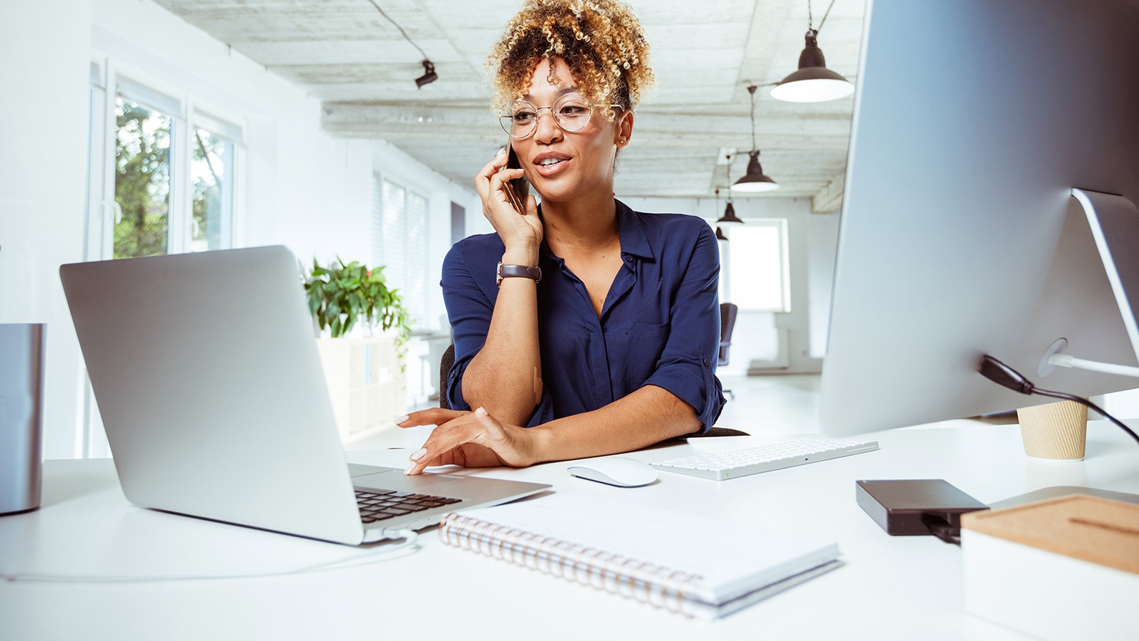 Woman discussing regulatory compliance services with a client on the phone.