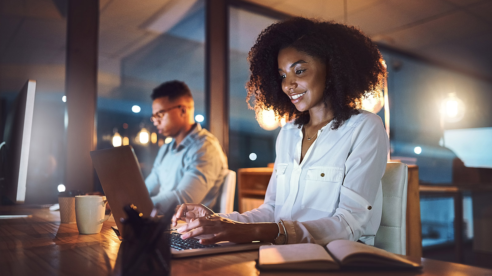 young businesswoman working on a laptop alongside her colleague on business solutions