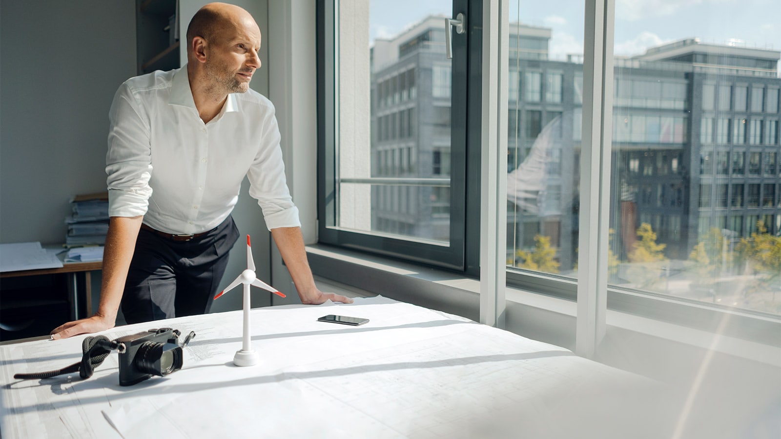 Un homme debout face à son bureau